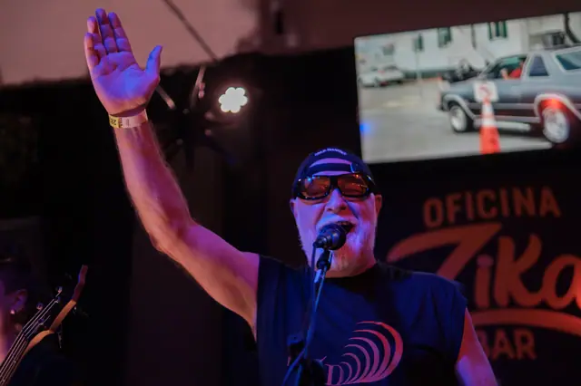 Vocalista da ZYD com o braço erguido em casa de show